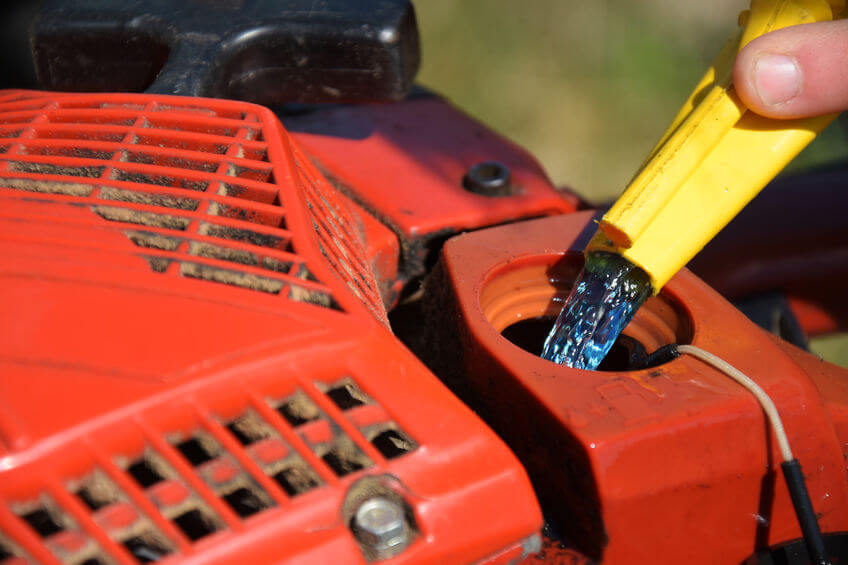 A chainsaw gas tank being cleaned with water